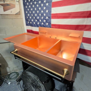 Raw Copper double bowl kitchen farmhouse sink with gold towel rack in front of an American flag. Made in USA