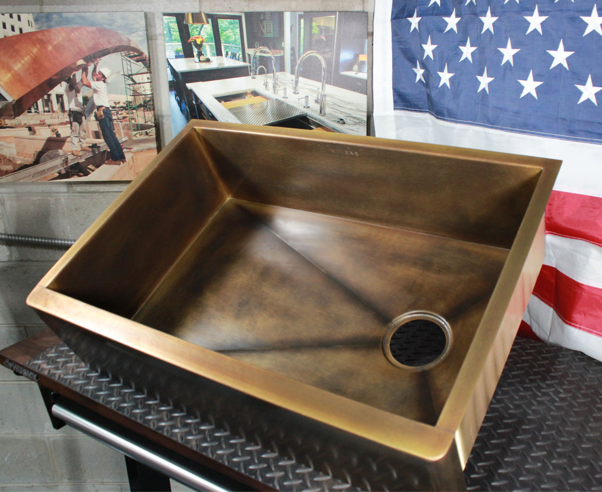 Custom natural aged brass farmhouse sink, top view of basin and right offset drain