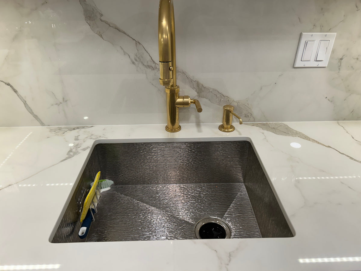 royal oak stainless steel sink in white marble countertop with brass faucet