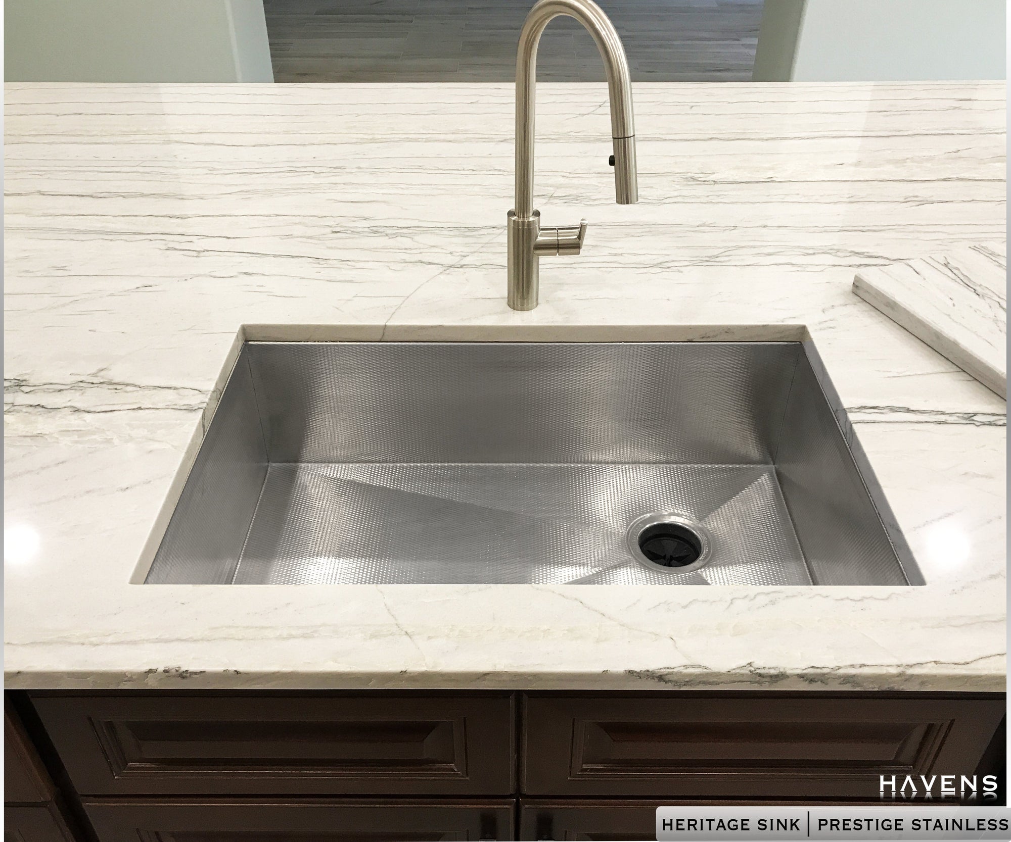 Undermount stainless steel kitchen sink under white granite countertops. Textured 16 gauge stainless steel