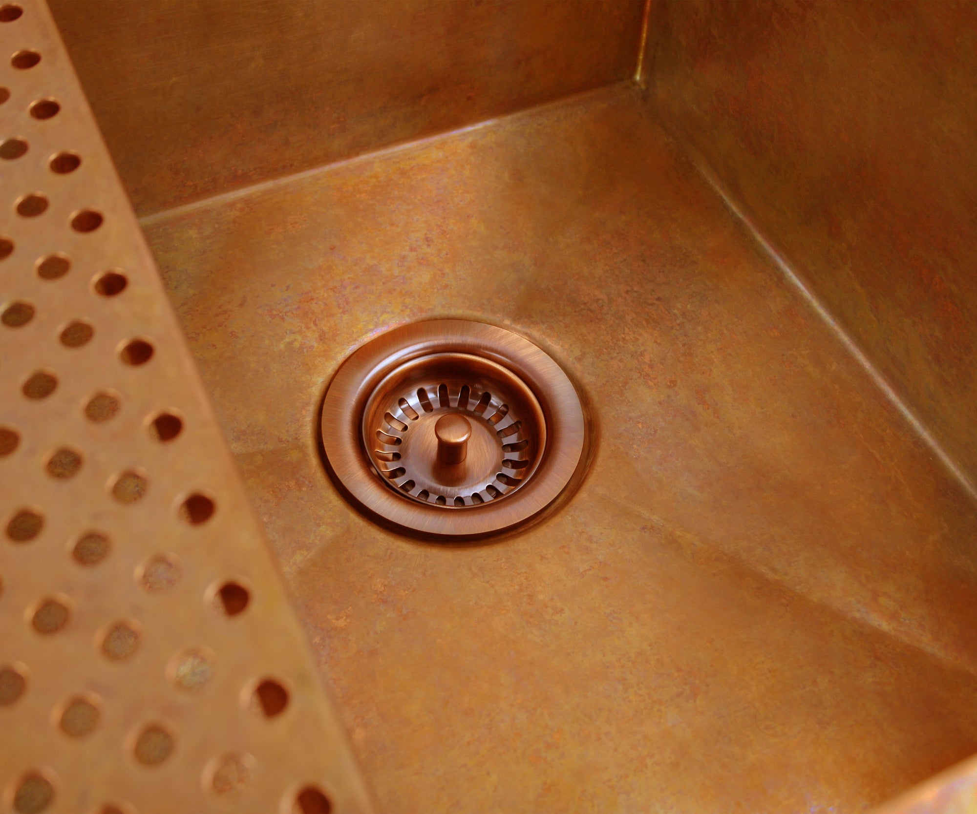 Havens | Luxury Metals custom copper sink with copper sink drain installed off-center 