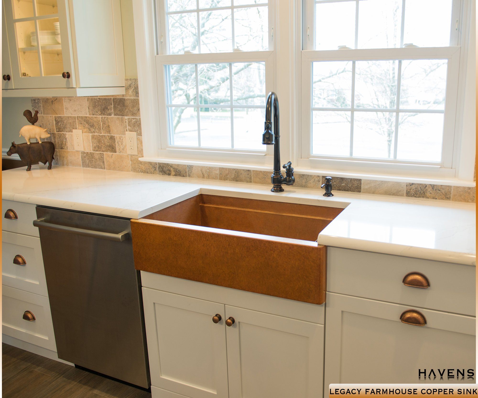 Large farmhouse sink with a brown copper patina and prominent apron front.