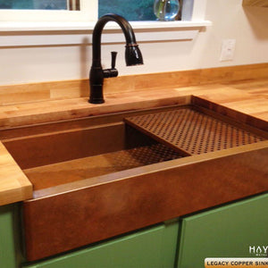 Legacy copper farm style kitchen sink installed as an undermount with a copper faucet.